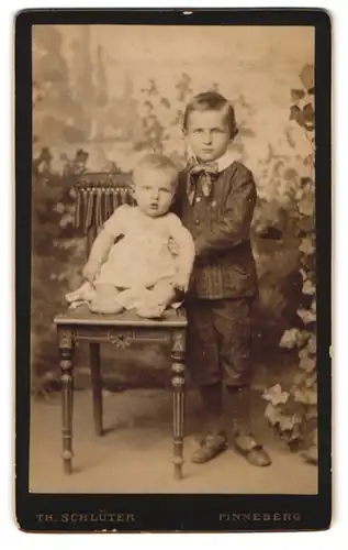 Fotografie Th. Schlüter, Pinneberg, Portrait hübsch gekleideter Junge mit einem Kleinkind