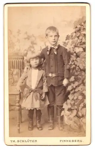 Fotografie Th. Schlüter, Pinneberg, Portrait kleiner Junge mit Schwesterchen in zeitgenössischer Kleidung