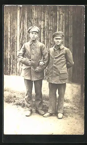 Foto-AK Zwei Kriegsgefangene vor Holzwand