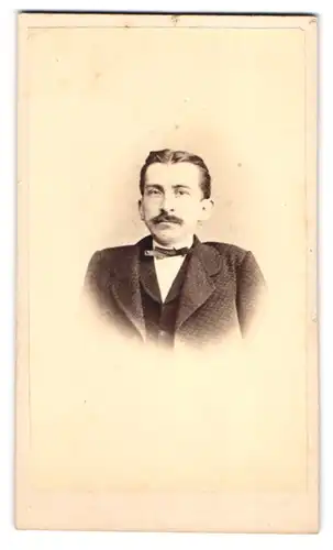 Fotografie L. Brade, Geestemünde, Portrait Herr im karierten Anzug mit Fliege und Moustache