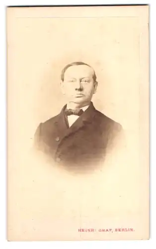 Fotografie Heinr. Graf, Berlin, Friedrichs-Str. 165, Portrait Mann im Anzug mit stolz geschwellte Brust und Fliege