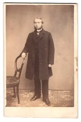 Fotografie unbekannter Fotograf und Ort, Portrait junger Mann im Anzug mit Mantel und Shin Strap Bart