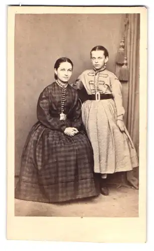 Fotografie unbekannter Fotograf und Ort, Portrait Mutter im karierten Kleid mit Tochter im Biedermeierkleid, Mutterglück