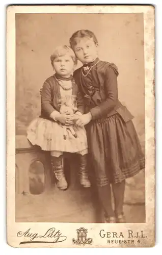 Fotografie Aug. Lutz, Gera, Neue Strasse 4, Schwestern in Kleidern und mit Puppe