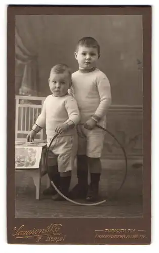 Fotografie Samson & Co., Berlin, Turmstrasse 76 A, Portrait zwei modisch gekleidete Jungen mit Reifen