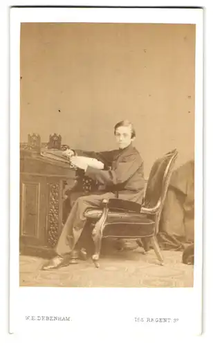 Fotografie W. E. Debenham, London, 158 Regent Street, Portrait Knabe im Anzug sitzend am Sekretär, 1864