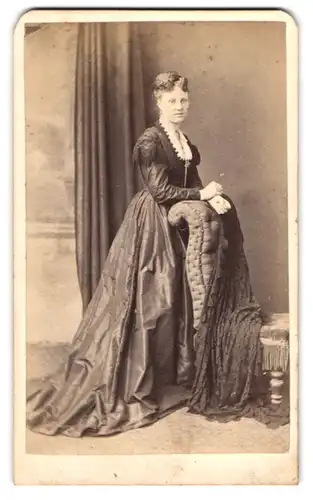 Fotografie A. Wilcox, Bristol, 50 Park St., Portrait Dame im Biedermeierkleid mit Haarnetz stehend am Stuhl