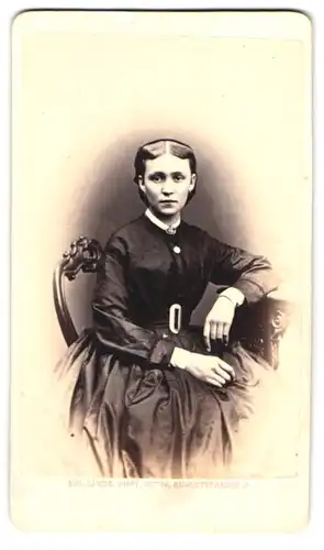Fotografie Aug. Linde, Gotha, Auguststr. 3, Portrait junge Frau im schwarzen Biedermeierkleid mit Brosche