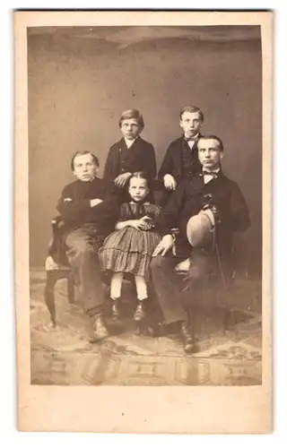Fotografie unbekannter Fotograf und Ort, Portrait Vater mit vier Kindern in Anzügen posieren im Atelier