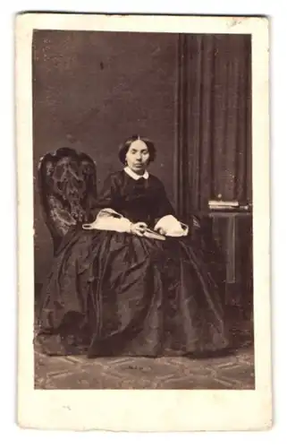 Fotografie unbekannter Fotograf und Ort, Portrait Frau im dunklen reifrock Kleid mit Buch in der Hand