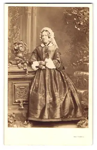 Fotografie Southwell Brothers, London, 16 & 22 Baker St., ältere Dame im seidenen Biedermeierkleid mit Haube, 1863