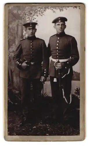 Fotografie Albert Steiger, Indersdorf, Portrait zwei Soldaten in Uniform mit Säbel vor einer Studiokulisse