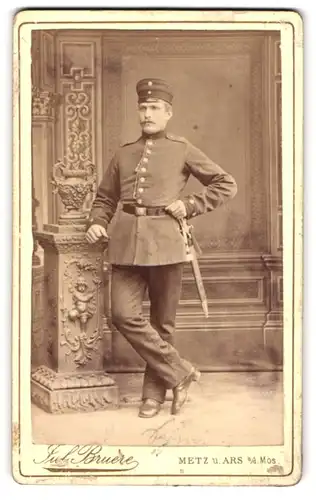 Fotografie Jul. Bruere, Metz, Rattenthurmstr. 8, Portrait Soldat in Uniform Rgt. 16 mit Bajonett lehnt an einer Säule