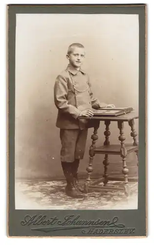 Fotografie Albert Johannsen, Haderslev, Junger Mann mit Mantel und Album