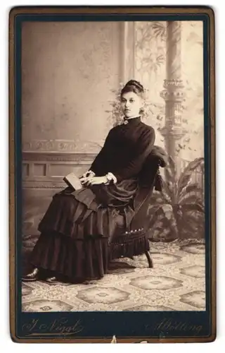 Fotografie J. Niggl, Altötting, Junge Frau in schwarzem Kleid und mit Buch