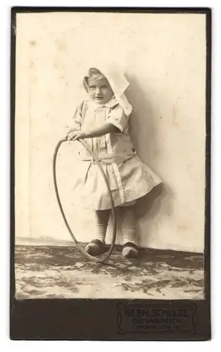 Fotografie Gebr. Schulze, Osnabrück, Grossestrasse 19, Portrait kleines Mädchen im Kleid mit Reifen