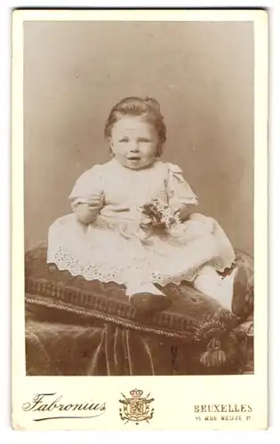 Fotografie Fabronius, Bruxelles, Rue Neuve 11, Baby mit dicken Wangen im Rüschenkleid