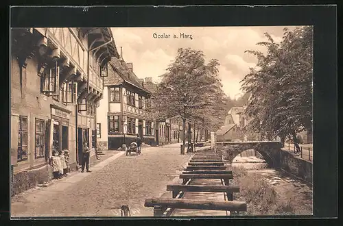AK Goslar / Harz, Strassenpartie mit Fachwerkhäusern, Flusspartie mit Brücke