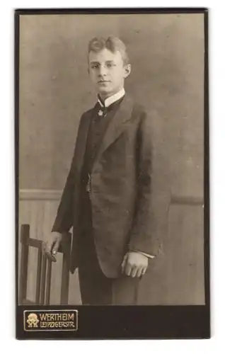Fotografie Wertheim, Berlin, Leipzigerstrasse, Portrait junger Mann im Anzug mit Zwicker