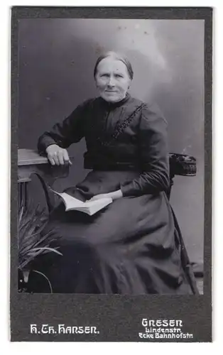 Fotografie H. Chr. Hansen, Gnesen, Lindenstrasse Ecke Bahnhofstrasse, Portrait ältere Dame im Kleid mit Buch