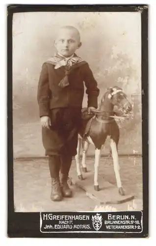 Fotografie H. Greifenhagen, Berlin, Brunnenstr. 18, kleiner Knabe im Anzug mit Schaukelpferd