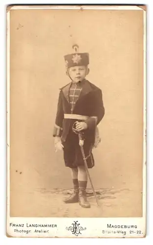 Fotografie Franz Langhammer, Magdeburg, Breite-Weg 21-22, Knabe in Husaren Uniform mit Säbel und Kolpak