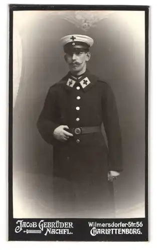 Fotografie Jacob Gebrüder Nachf., Berlin-Charlottenburg, Wilmersdorferstr. 56, Portrait Sanitäter in Uniform mit Brille