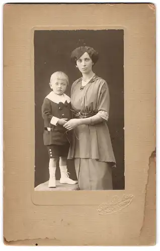 Fotografie Paulsen, Lübeck, Portrait Mutter im Kleid mit Sohn im Anzug, Mutterglück