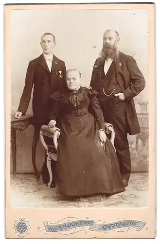 Fotografie A. Jandorf & Co., Berlin, Portrait Mutter und Vater mit Sohn und Miniaturorden an der Brust