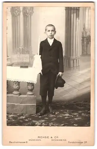 Fotografie Rhese & Co., München, Beichstr. 8, Portrait junger Knabe im Anzug mit Kommunionskerze