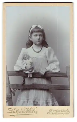 Fotografie Lutze & Witte, Magdeburg, Breiteweg 32/33, Portrait niedliches Kind Lotte Schlimsen im Kleid mit Puppe im Arm