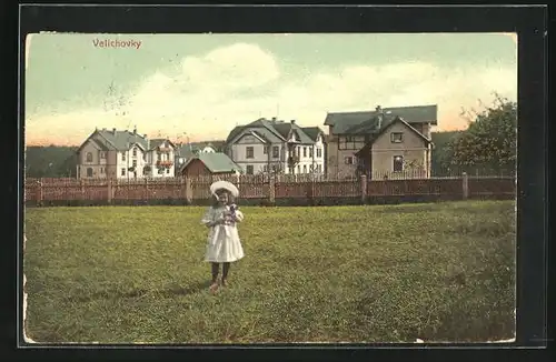 AK Velichovky, Mädchen auf einer Wiese vor dem Ort