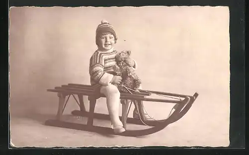 Foto-AK Kleinkind auf Schlitten mit Teddy