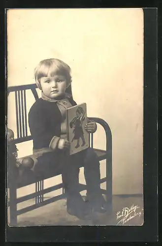 Foto-AK Kind mit Bilderbuch sitzt auf einer Bank
