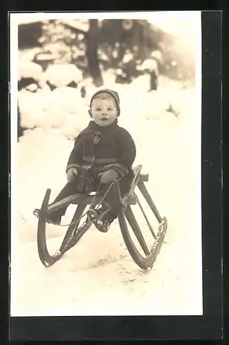 Foto-AK Kleiner Junge in winterlicher Kleidung auf Schlitten