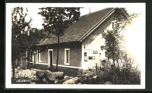 AK Jezero, Mädchen vor einem Haus mit Emailleschildern