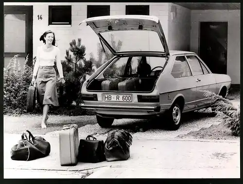 Fotografie Auto VW Passat Limousine, Dame verstaut Reisegepäck im Volkswagen