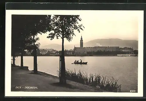 AK Dux / Duchcov, Ruderboot auf ruhigem See, Blick auf Stadt