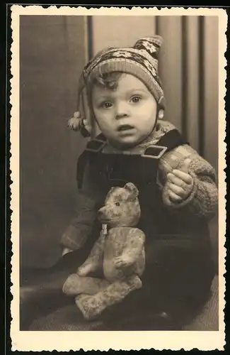 Fotografie Knabe mit Teddybär & Bommelmütze
