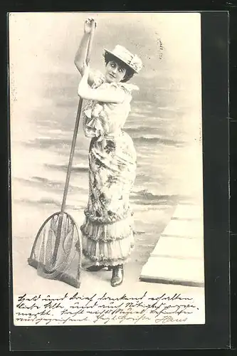 AK Frau mit Fischernetz am Strand stehend