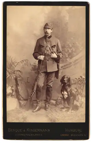 Fotografie Benque & Kindermann, Hamburg, Grosse Bleichen 30, Portrait Jäger mit seinem Jagdhund und Flinte im Atelier