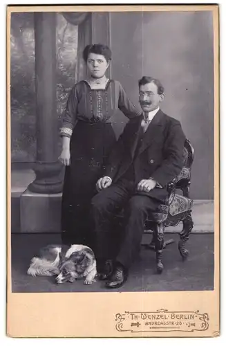 Fotografie Th. Wenzel, Berlin, Portrait junges Paar im Biedermeierkleid und Anzug mit ihrem Hund zu Füssen