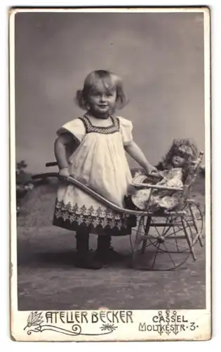 Fotografie Atelier Becker, Cassel, Moltkestr. 3, Portrait niedliches Mädchen im Kleidchen mit Puppenwagen und Puppe