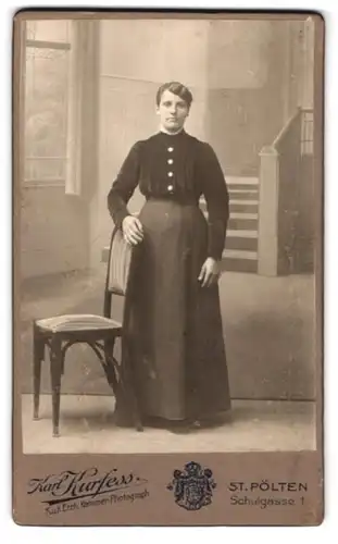 Fotografie Karl Kurfess, St. Pölten, Portrait junge Frau im Biedermeierkleid mit Stuhl vor einer Studiokulisse