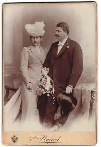Fotografie Atelier Rafael, Brünn, Portrait Brautpaar Hans und Helen im Hochzeitskleid und Anzug mit Zylinder, 1900