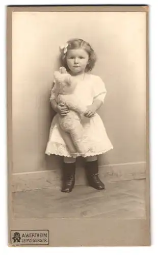 Fotografie A. Wertheim, Berlin, Portrait niedliches Mädchen im weissen Kleid it Teddybär im Atelier