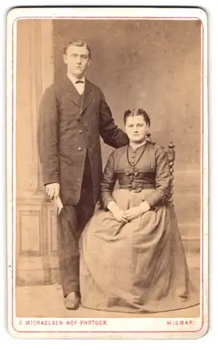 Fotografie C. Michaelsen, Wismar, Portrait junges Paar im Biedermeierkleid und Anzug mit Fliege