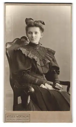 Fotografie Atelier Wertheim, Berlin, Portrait junge Frau im schwarzen Kleid mit Haarschleife