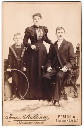 Fotografie Franz Kuhlmey, Berlin, Portrait Mutter und Vater mit ihrem Sohn im Atelier, Matrosenanzug