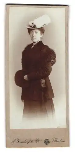 Fotografie A. Jandorf & Co., Berlin, Portrait Dame im Winterkleid mit Federhut und Muff